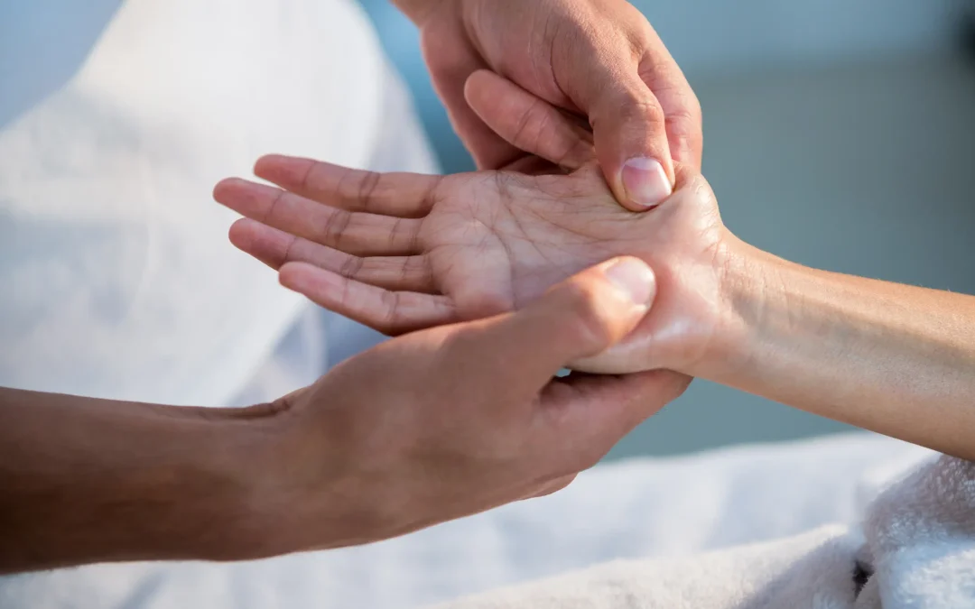 Fisioterapeuta trabajando la sensibilidad de la mano de una paciente con dolor neuropático en una sesión de neurorrehabilitación a domicilio en Málaga