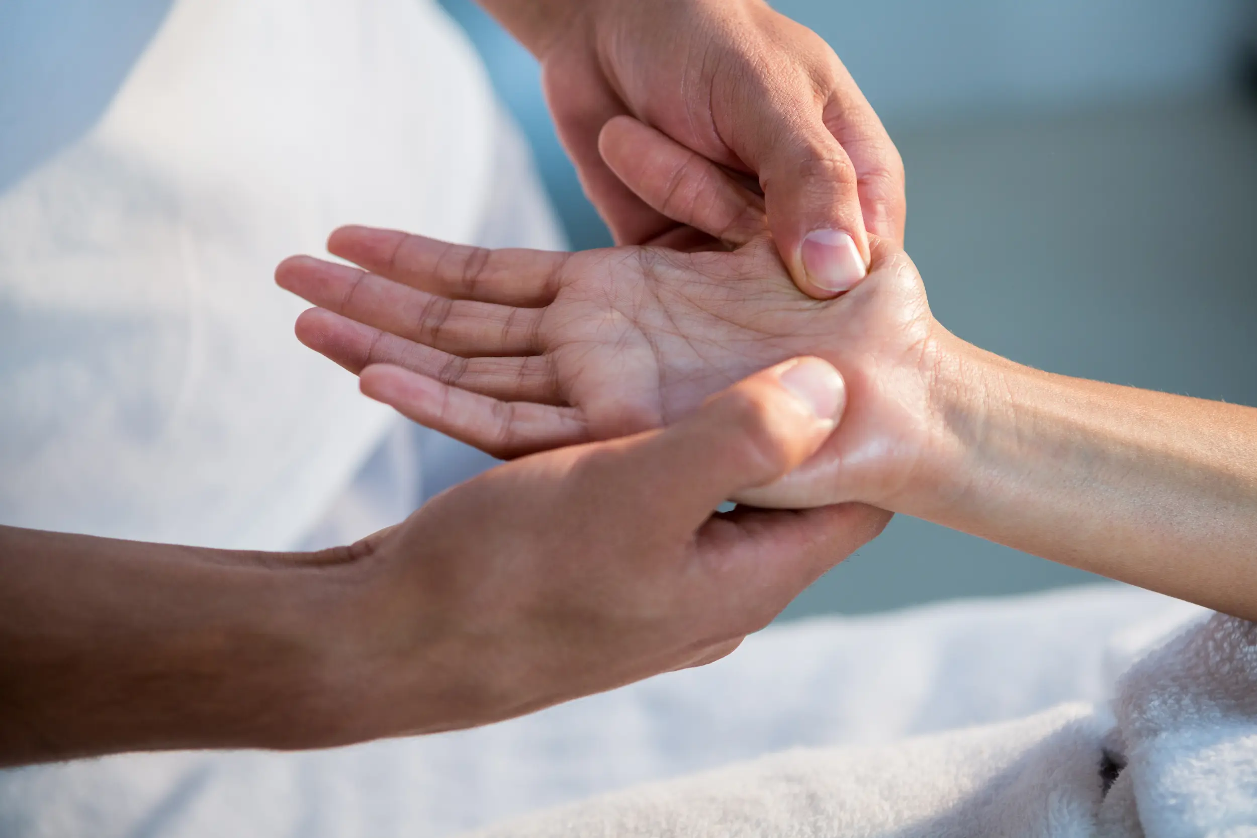 Fisioterapeuta trabajando la sensibilidad de la mano de una paciente con dolor neuropático en una sesión de neurorrehabilitación a domicilio en Málaga
